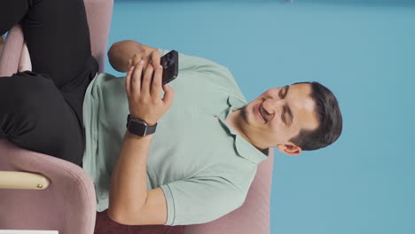 Vertical-video-of-Happy-and-happy-texting-man.